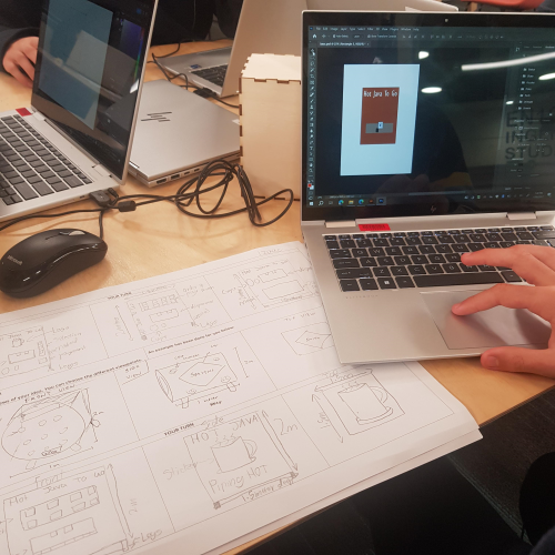 Sketches of vending machine designs and a laptop with a student working on an app design